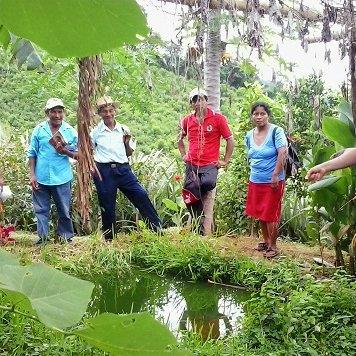 Comunidad campesina reunida junto a una fuente de agua en zona rural